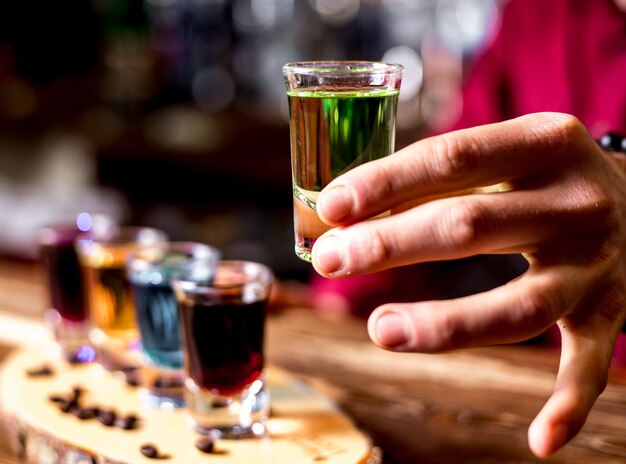 Vista lateral, um homem bebe fotos coloridas com grãos de café em um pedaço de madeira