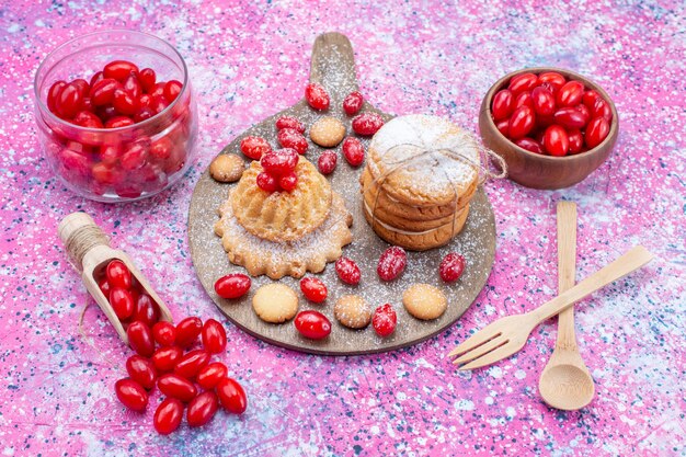 Vista mais de perto da metade do topo biscoitos recheados cremosos com dogwoods vermelhos frescos em uma mesa iluminada, biscoito com bolo de frutas azedas