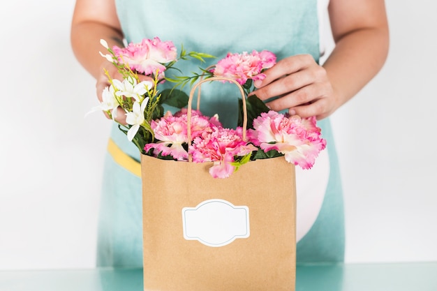 Vista mestra, de, florista feminino, com, flor, sacola papel