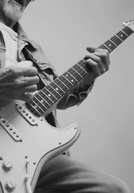 Vista monocromática de uma pessoa tocando guitarra elétrica