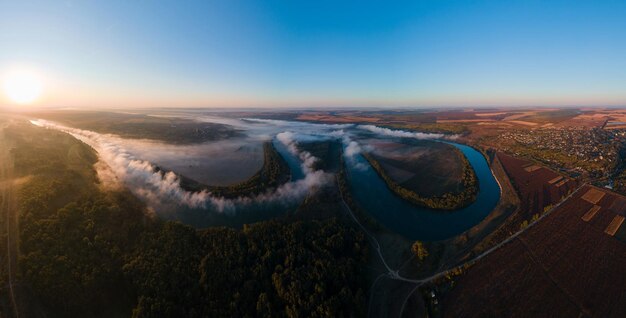 Vista panorâmica aérea de drones sobre a natureza da Moldávia no rio do nascer do sol com campos largos de floresta de nevoeiro