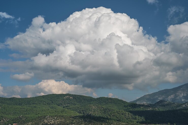 Foto grátis vista panorâmica das montanhas com pinheiros e nuvens fofas brancas tiro panorâmico das montanhas ao meio-dia na costa do mar egeu