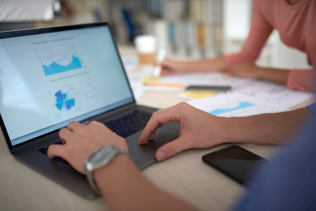 Vista por cima do ombro da tela do laptop mostrando os dados estatísticos financeiros