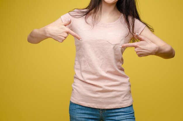 Vista recortada da morena em pé na camisa branca e calça jeans