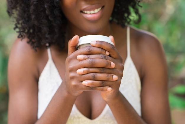 Vista recortada de mulher negra bebendo no parque