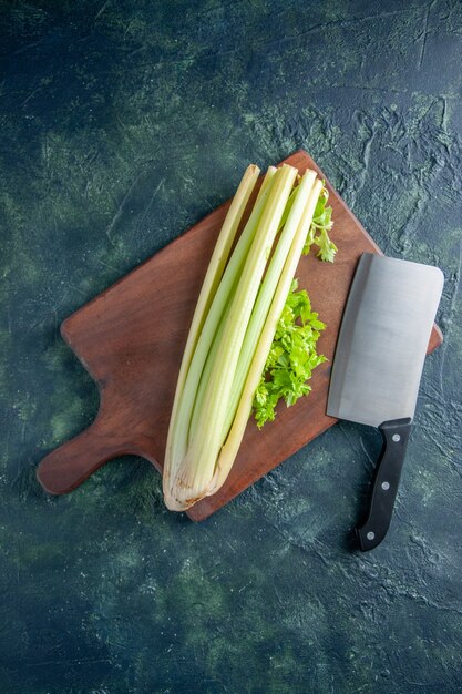 Vista superior aipo verde fresco com uma grande faca em uma superfície azul escuro salada dieta alimentar refeição foto colorida