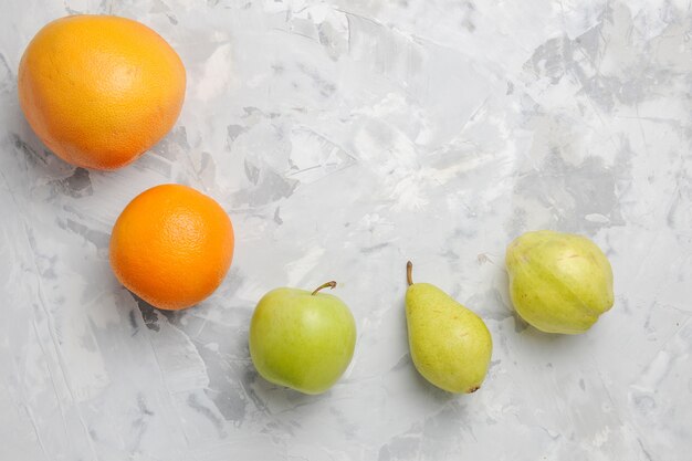 Vista superior alinhada com frutas frescas, peras e tangerinas no fundo branco