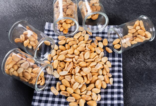 Vista superior amendoins em frascos na toalha de mesa em pedra horizontal
