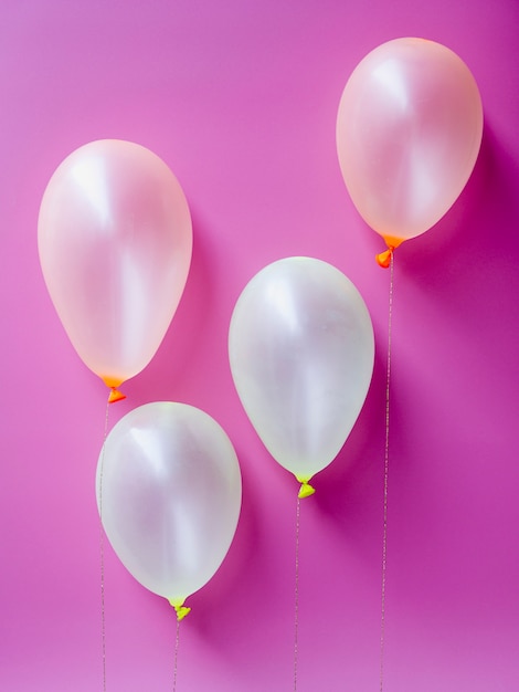 Vista superior balões brancos em fundo rosa