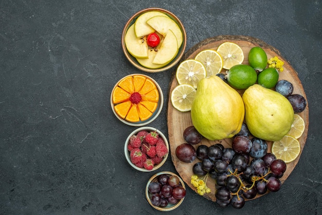 Foto grátis vista superior composição de frutas diferentes frescas e maduras em fundo cinza escuro frutas maduras maduras saúde planta cor