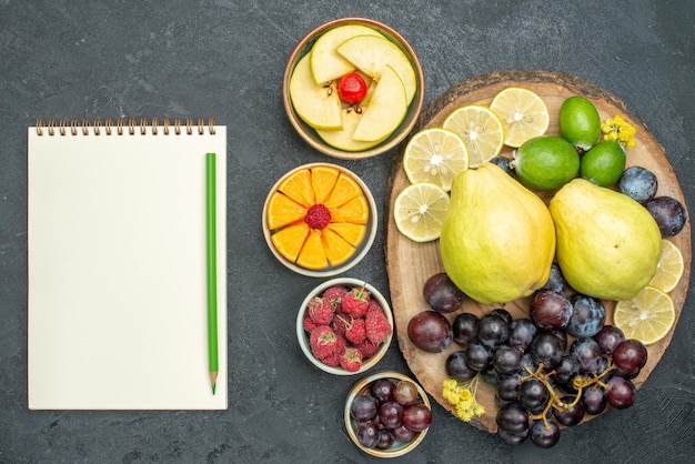 Vista superior composição de frutas diferentes frescas e maduras no fundo cinza escuro frutas maduras planta saudável cor suave