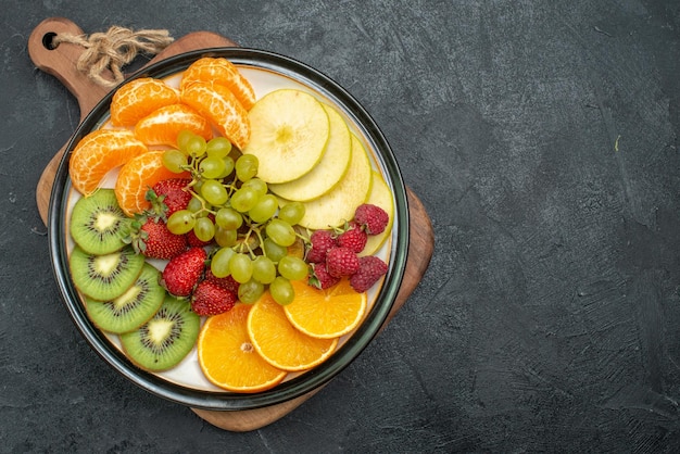 Vista superior composição de frutas diferentes frescas fatiadas e maduras em fundo cinza frutas frescas maduras saúde maduras