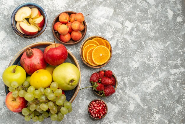 Vista superior composição de frutas frescas maçãs ameixas uvas e outras frutas no fundo branco frutas frescas maduras vitamina madura