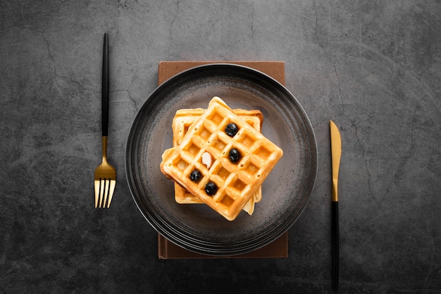 Vista superior conjunto de dois waffles com talheres de ouro