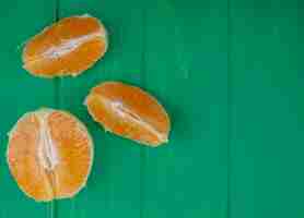 Foto grátis vista superior cópia espaço fatias de laranja descascadas em fundo verde