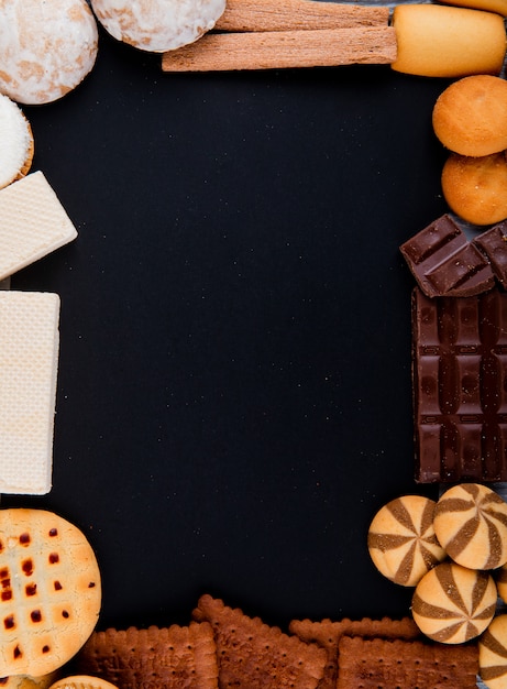 Vista superior cópia espaço mix de biscoitos com chocolate e waffles em um fundo preto