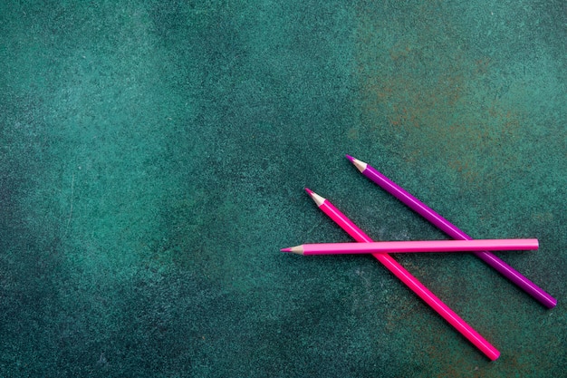 Vista superior cópia espaço rosa lápis sobre fundo verde