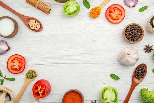 Vista superior corte colheres de pau de legumes com pimentão e feijão, tomate e canela