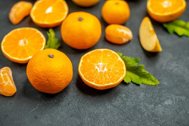 Vista superior, corte de laranjas e tangerinas em fundo escuro