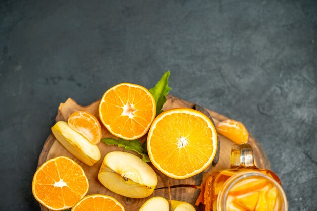 Vista superior corte laranjas e maçãs cortadas laranja na superfície escura