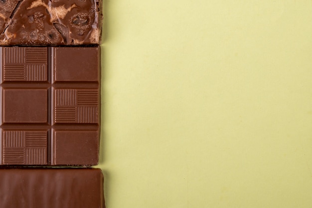 Vista superior da barra de chocolate na luz colorida de fundo com espaço de cópia