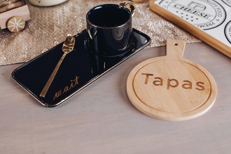 Foto grátis vista superior da caneca de café preta perto de uma tábua de madeira para queijo. copie o espaço