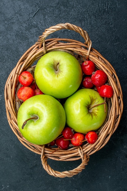 Vista superior da cesta com frutas, maçãs e cerejas doces na árvore de frescor de composição de frutas com frutas e bagas