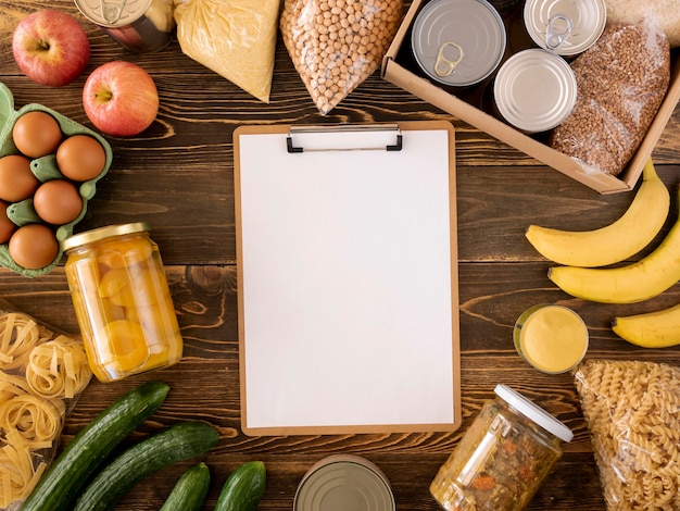 Vista superior da comida para doação com caixa e bloco de notas