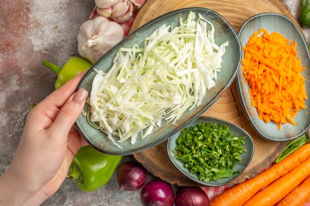 Vista superior da composição de vegetais fatiados e vegetais inteiros em fundo branco