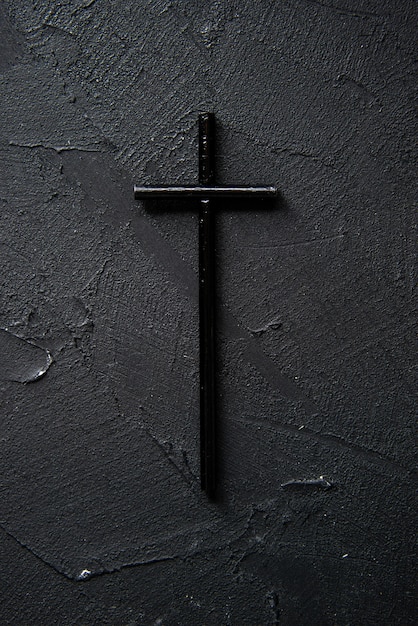 Foto grátis vista superior da cruz negra na parede escura