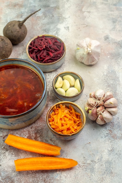 Vista superior da deliciosa sopa borscht com ingredientes picados e inteiros em uma mesa colorida