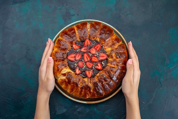 Vista superior da deliciosa torta de morango na superfície azul escura