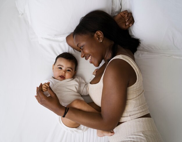 Vista superior da mãe na cama com o bebê recém-nascido