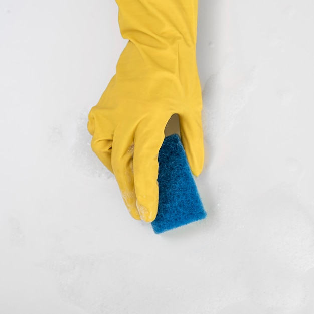 Foto grátis vista superior da mão com luva de limpeza segurando a esponja