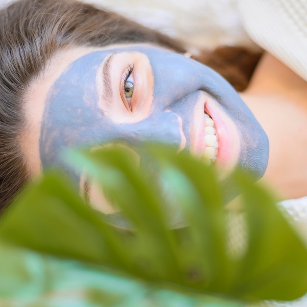 Vista superior da mulher relaxando em casa com máscara facial