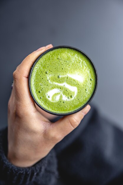 Vista superior da mulher segurando na moda bebida matcha verde de mãos com latte art