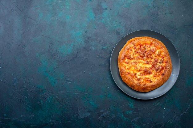 Vista superior da pizza assada dentro do prato no escuro