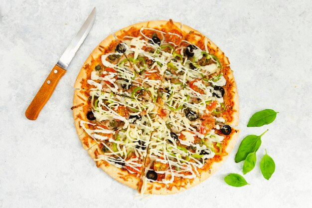 Vista superior da pizza com faca e hortelã