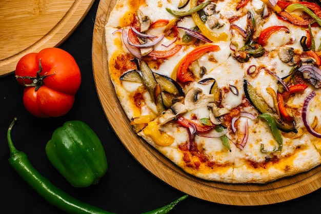 Vista superior da pizza vegetariana com berinjela, pimentão, cebola roxa, tomate e cogumelo