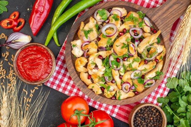 Vista superior da salada de frango com vegetais e temperos na superfície escura