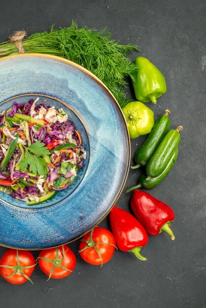 Vista superior da salada de repolho fresco com verduras e legumes em fundo escuro