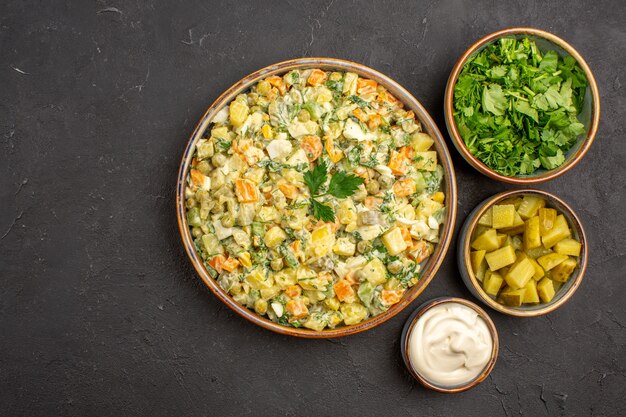 Vista superior da salada de vegetais com maionese em superfície escura