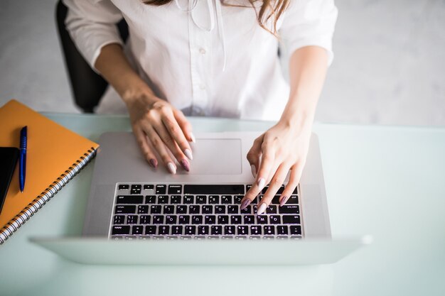 Vista superior da senhora do escritório durante seu trabalho no laptop em um escritório moderno