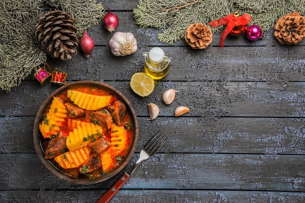 Vista superior da sopa carnuda com verduras e batatas na mesa escura