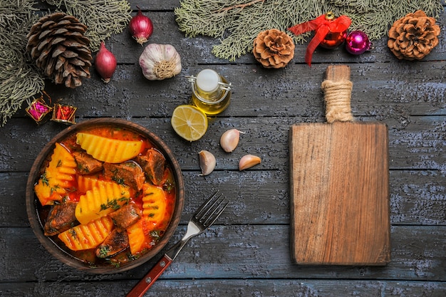 Vista superior da sopa carnuda com verduras e batatas na mesa escura