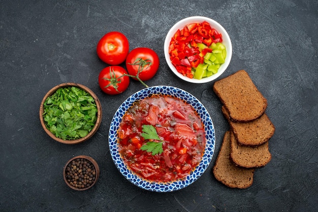 Foto grátis vista superior da sopa de borsch com pão preto e verduras em espaço escuro