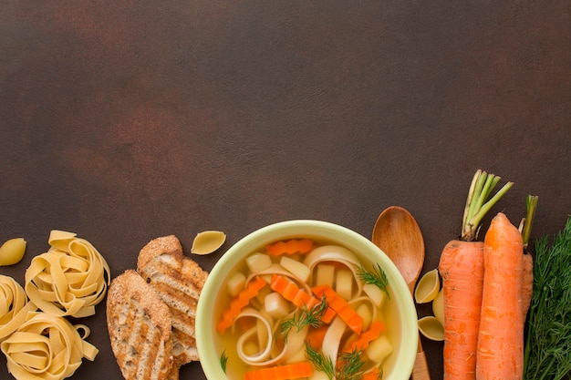 Vista superior da sopa de legumes de inverno em uma tigela com torradas e tagliatelle
