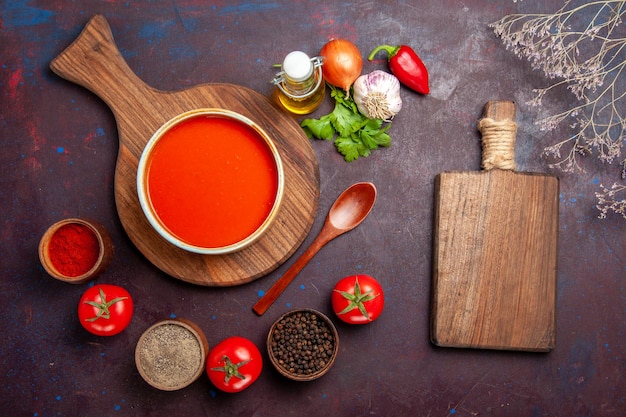 Vista superior da sopa de tomate com temperos no preto