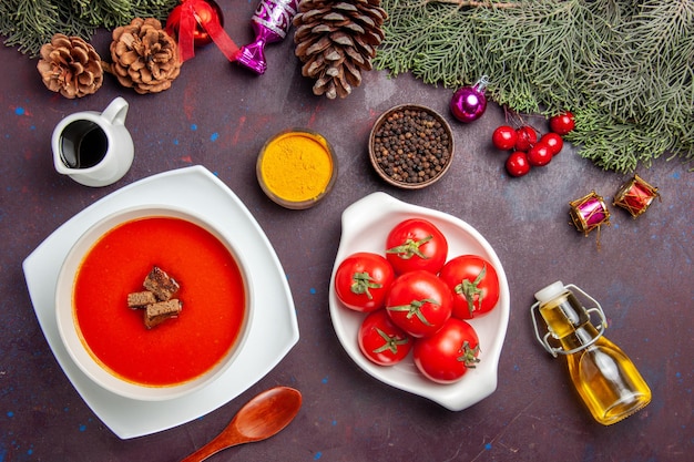 Vista superior da sopa de tomate com tomates frescos e temperos no preto