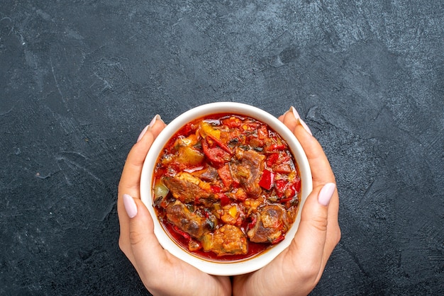 Vista superior da sopa de vegetais com carne na cinza